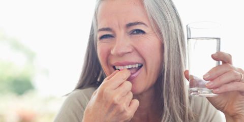 vrouw neemt multivitaminen in